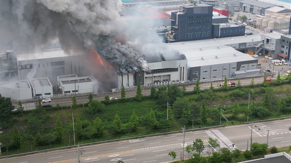  24일 오전 경기 화성시 서신면의 일차전지 제조 업체 공장에서 불이 나 소방 당국이 진화에 나섰다. 사진은 연기가 치솟는 공장 건물.