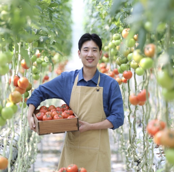  자신의 스마트팜에서 수확한 토마토를 들고 있는 오훈민 씨