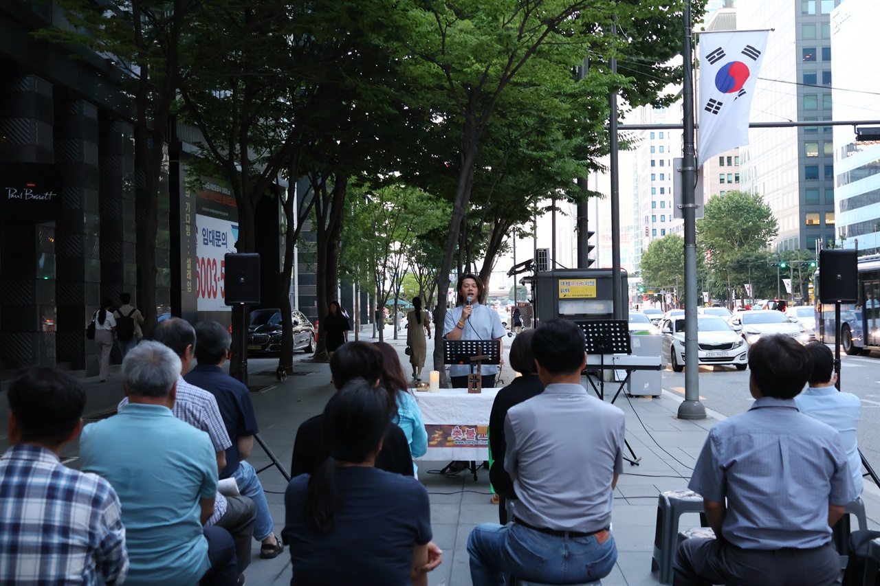 촛불교회가 27일 저녁 테헤란로에 위치한 닛토덴코 서울사무소 앞에서 '한국옵티칼하이테크 문제해결을 위한 기도회'를 개최했다.