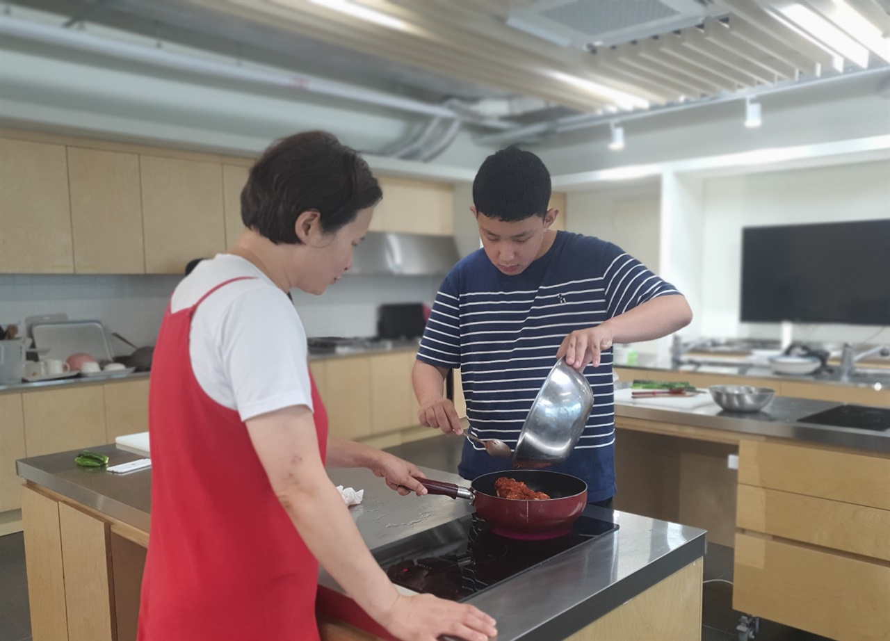 주원은 양념한 고기를 프라이팬에 옮겼다. 요리 활동은 발달장애 아동의 신체 협업 능력을 키운다.