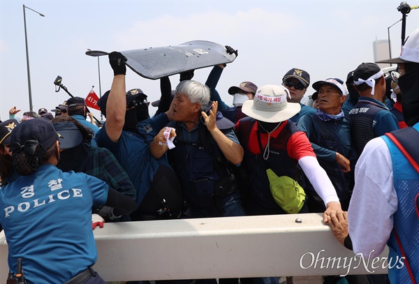  ‘기후재난 시대, 농민생존권 쟁취와 국가책임농정 실현을 위한 전국농민대회’가 7월 4일 오후 여의도 국회앞에서 농민의길 주최로 열릴 예정인 가운데, 일부 참가자들이 마포대교에서 ‘국가책임 농정 실현하라’가 적힌 현수막을 들고 기습 시위를 벌였다. 경찰이 마포대교를 행진하는 농민들을 제지하고 있다.