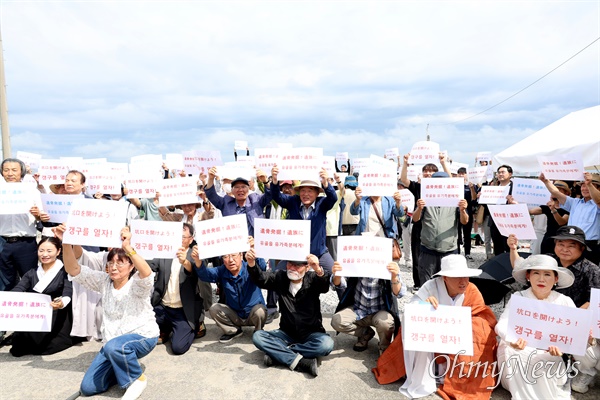  지난 15일 일본 야마구치현 우베시 장생탄광 추모비 앞에서 열린 추모행사 후 참가자들이 '갱구를 열자' 등이 쓰인 피켓을 들어보이고 있다.