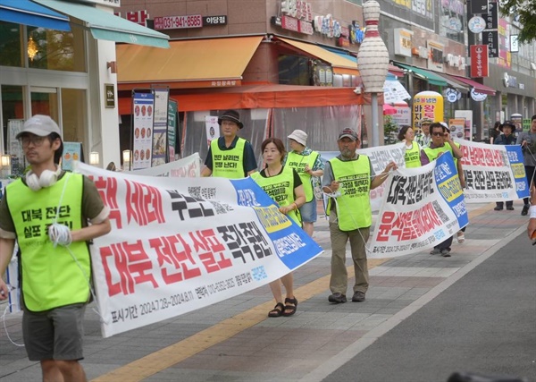  감시단이 현수막을 들고 행진하고 있다.