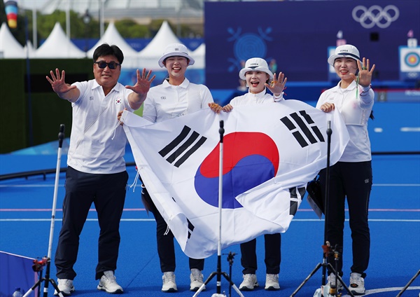  전훈영, 임시현, 남수현이 28일(현지시간) 프랑스 파리 레쟁발리드 양궁 경기장에서 열린 2024 파리올림픽 양궁 여자단체 결승전에서 우승을 확정한 뒤 태극기를 펼치고 있다.