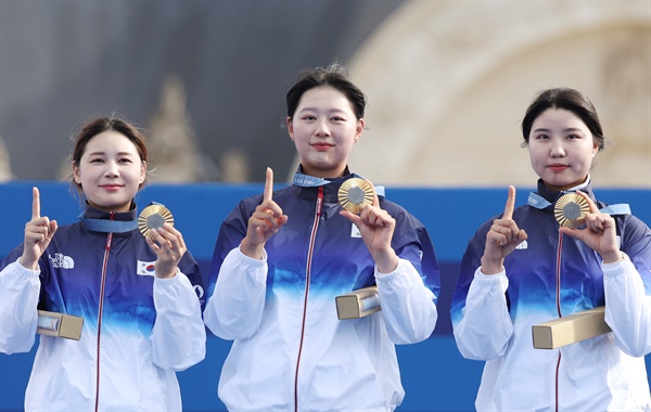  올림픽 10연패를 달성한 한국 여자양궁 대표팀의 남수현(오른쪽부터), 임시현, 전훈영이 28일(현지시간) 프랑스 파리 레쟁발리드 양궁 경기장에서 열린 2024 파리올림픽 양궁 여자단체전 시상식에서 손가락과 금메달로 숫자 10을 만들며 기념 촬영을 하고 있다.