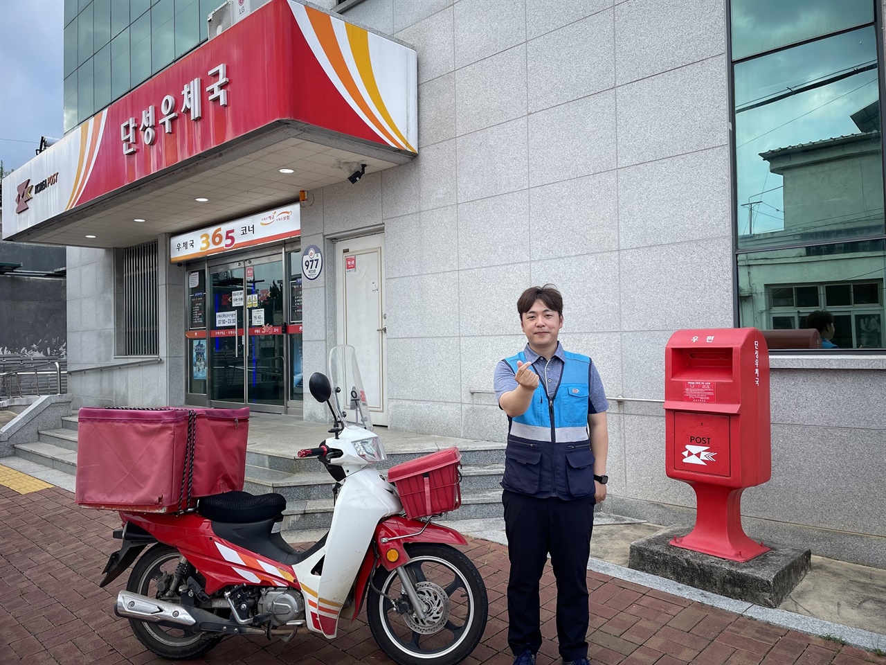  한밤중 거리를 헤매던 90대 국가유공자를 가족 품으로 인계한 산청우체국 소속 단성우체국 정세영 집배원이 우체국 앞에서 환하게 웃고 있다.