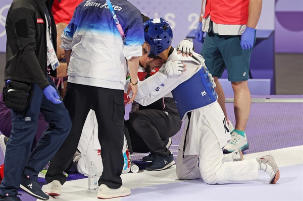  7일(현지시간) 프랑스 파리 그랑팔레 태권도경기장에서 열린 2024 파리올림픽 태권도 남자 58kg급 결승전에서 승리한 한국 박태준이 부상으로 힘들어하는 아제르바이잔 가심 마고메도프를 위로하고 있다. 상대 마고메도프는 결승전 도중 입은 부상으로 후송되고 있다. 