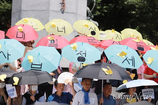  일본군'위안부' 피해자 기림의 날인 14일 부산시 동구 일본영사관 인근 항일거리에서 '역사부정 세력 규탄' 등을 내건 부산수요집회가 열리고 있다. 평화우산을 든 참석자들의 모습.