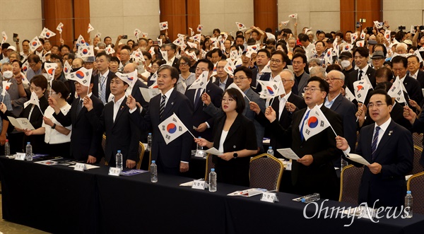  이종찬 광복회장과 박찬대 더불어민주당 당대표 직무대행 겸 원내대표, 조국 조국혁신당 대표, 용혜인 기본소득당 대표, 한창민 사회민주당 대표를 비롯한 시민들이 15일 오전 서울 용산구 백범김구 기념관에서 광복회, 56개 독립유공단체 주최로 열린 제79주년 광복절 기념식에 참석해 역사어린이합창단의 <독립군가> 노래에 맞춰 태극기를 흔들고 있다. 