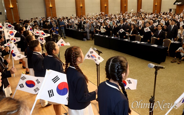  이종찬 광복회장과 박찬대 더불어민주당 당대표 직무대행 겸 원내대표, 조국 조국혁신당 대표, 용혜인 기본소득당 대표, 한창민 사회민주당 대표를 비롯한 시민들이 15일 오전 서울 용산구 백범김구 기념관에서 광복회, 56개 독립유공단체 주최로 열린 제79주년 광복절 기념식에 참석해 역사어린이합창단의 <독립군가> 노래에 맞춰 태극기를 흔들고 있다.