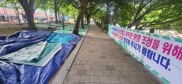  전북 무주군 구천동계곡에 깔린 돗자리들 앞으로 "불법행위 없도록 협조해달라"는 무주군수 명의의 현수막이 걸려 있다. 