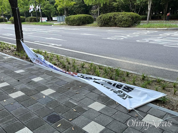  23일 독립기념관 정문 앞 1km 구간에 설치됐었던 '김형석 독립기념관장 아웃' 현수막들이 끈이 풀린 상태로 바닥에 떨어져 있다. <오마이뉴스> 확인 결과, 천안 동남구청이 현수막 10개를 철거했다. 