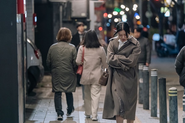  서울 길거리를 걷는 계나의 모습. 추위에 떨며 코트를 여민다.