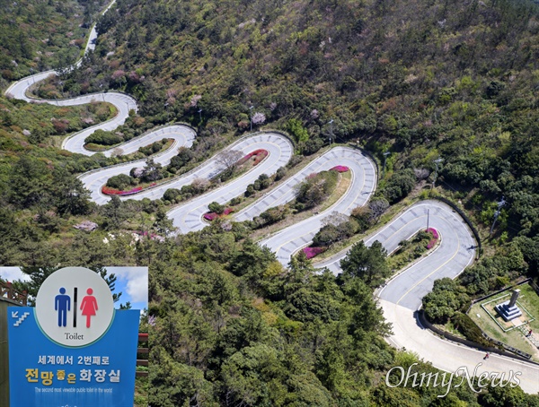  전남 신안 흑산도 12굽이길 정상부에 바다를 향해 설치된 '세상에서 2번째로 전망좋은 화장실'(작은 사진). 고갯길 정상부(큰 사진 오른쪽 아래)에 '흑산도 아가씨 노래비'가 세워져 있고, 노래비와 약 30m 거리에 전망 좋은 화장실이 장도와 홍도를 바라보며 설치돼 있다.