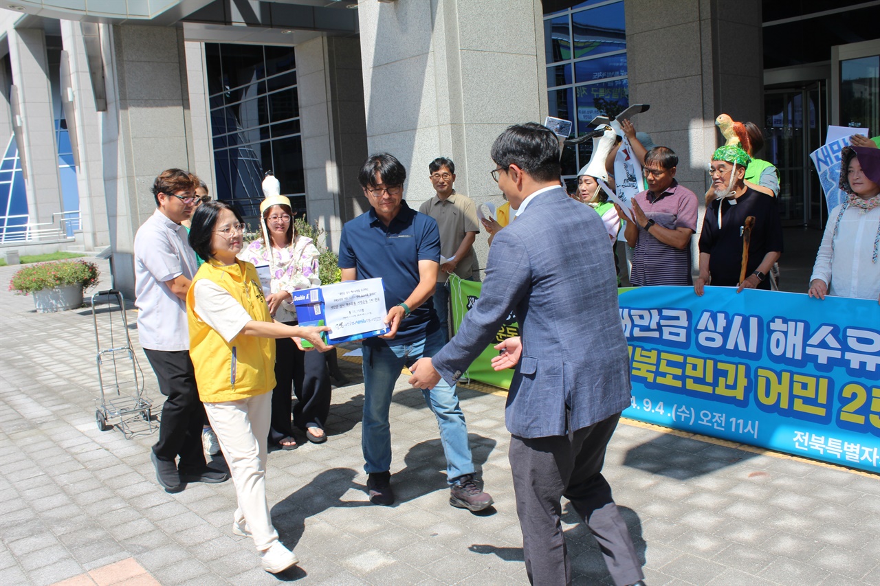  대표단이 전북특자도 권민호 새만금자원수질과장에게 서명 용지를 전달하고 있다