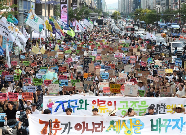  7일 서울 강남대로에서 열린 기후정의행진에서 참가자들이 손팻말을 들고 구호를 외치고 있다.