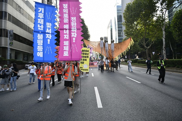  기후위기의 심각성을 알리는 대형 만장과 삼두매를 앞세운 거리 행진이 서울 강남의 한폭판에서 진행됐다.