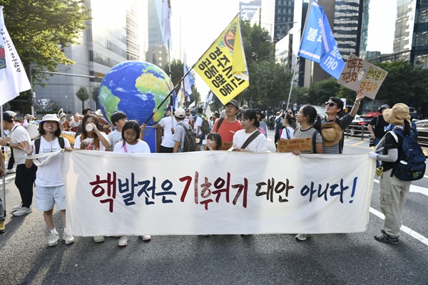  핵발전은 기휘위기 대안이 결코 아니다라고 적힌 현수막을 들고 경주에서 온 시민들이 퍼레이들를 펼치고 있다.