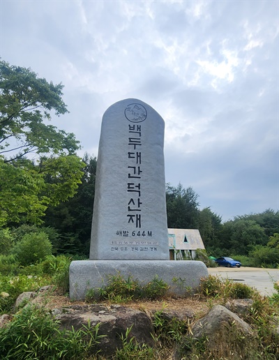  전북 무주와 경북 김천 경계와 위도 및 경도, '백두대간 덕산재' 문구가 적힌 큰 표지석.