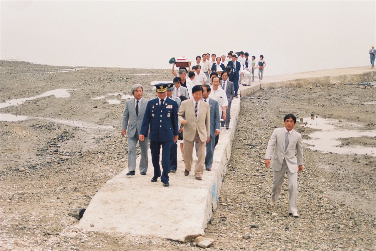  1987년 당진 상록회 회원들이 행담도를 방문하자 행담도 마을 주민들이 포구 앞까지 나가 방문객을 맞이하고 있다. 사진은 행담포구 모습이다.