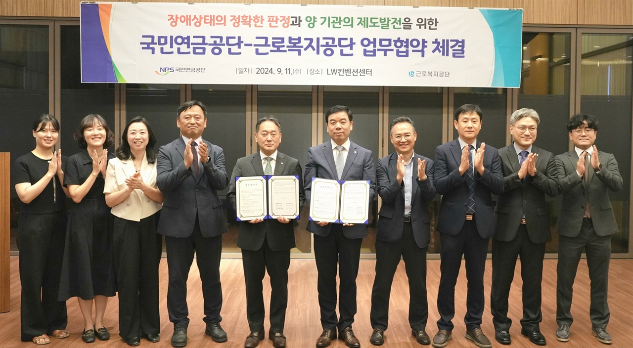  김태현 국민연금공단 이사장(왼쪽 5번째)과 박종길 근로복지공단 이사장(왼쪽 6번째)이 11일 서울 중구 LW컨벤션센터에서 '장애판정 자료 공유를 위한 업무협약' 후 직원들과 기념촬영을 하고 있다.