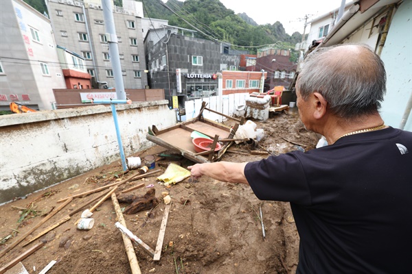  13일 오전 경북 울릉군 울릉읍 도동리 도동파출소 인근 주민이 진흙밭으로 변한 마당을 가리키고 있다. 지난 11일∼12일 울릉군에는 300㎜가 넘는 폭우가 쏟아졌다.