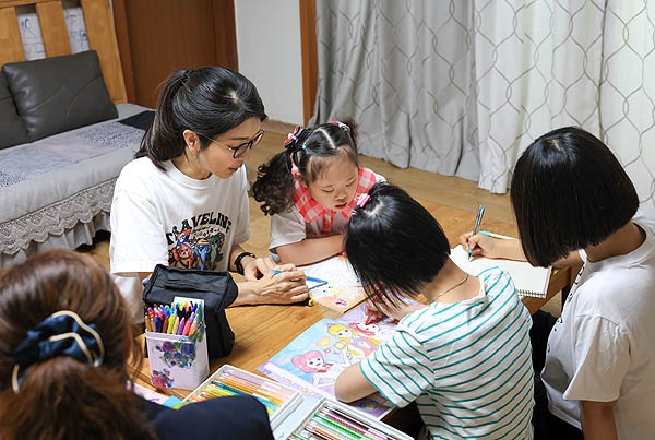  윤석열 대통령 부인 김건희 여사가 추석 연휴인 15일 서울 은평구 장애아동거주시설인 다움장애아동지원센터를 방문해 보조 교사와 함께 아이들이 그림책에 색연필로 색칠하는 것을 도와주고 있다. 