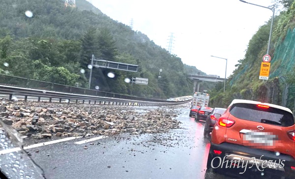  21일 오후 창원 불모산터널을 지나 부산 방향의 부산~창원 민자도로에 폭우로 인해 돌이 상당히 많이 떨어져 있어 차량들이 갓길로 통행하고 있다.