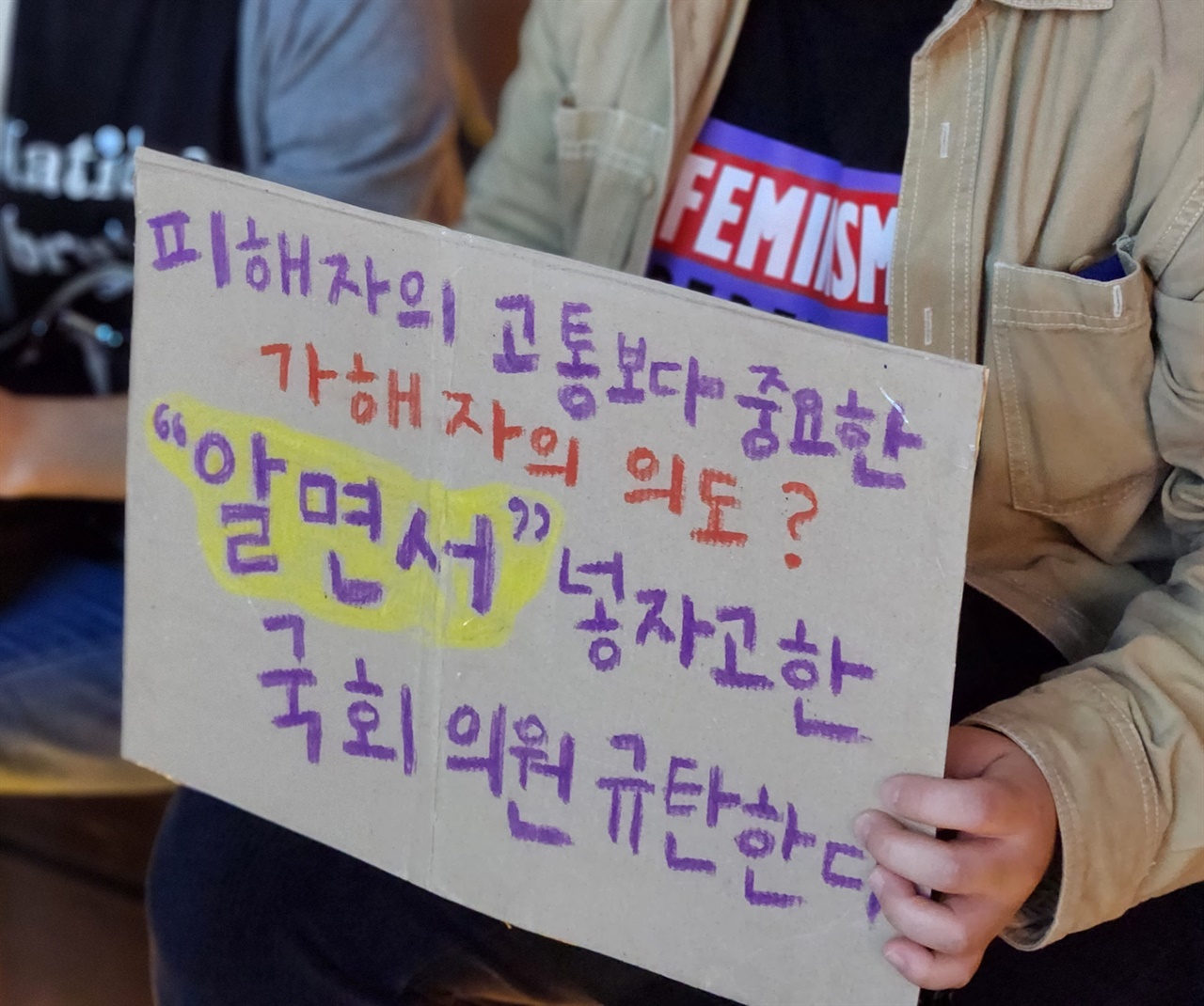 '알면서' 넣자고 한 국회의원 규탄한다 공동행동에 참여한 시민이 딥페이크 처벌법 조항에 '알면서'를 넣어 가해자의 의도를 기준으로 삼자고 했던 국회의원들을 규탄하는 손피켓을 들고 있다.