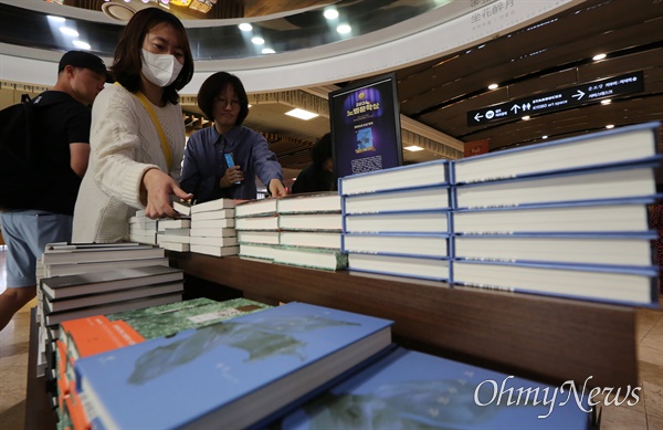 한강 작가, 한국인 최초 노벨문학상 수상 한국인 최초로 노벨문학상을 수상한 한강 작가의 책들이 11일 오전 서울 종로구 교보문고 광화문점에 진열되어 있다. 시민들이 추가로 진열된 소설 '소년이 온다'와 '채식주의자'를 구입하고 있다.