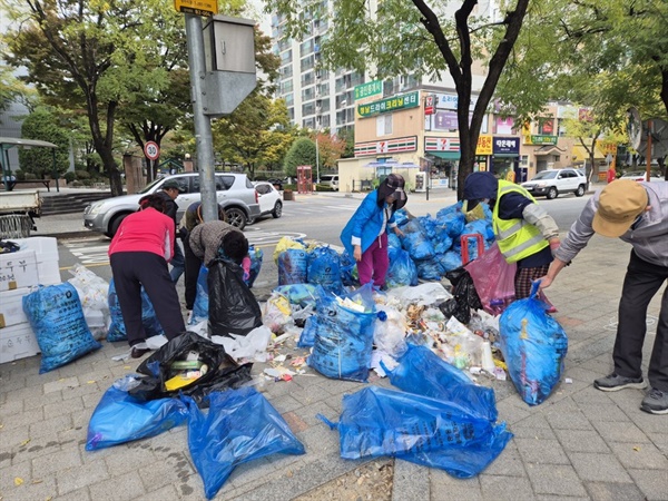  13일 박성호 분평동 노인회장과 회원들이 배출된 쓰레기를 다시 재활용과 재활용될수 없는 것으로 분류하고 있다.  