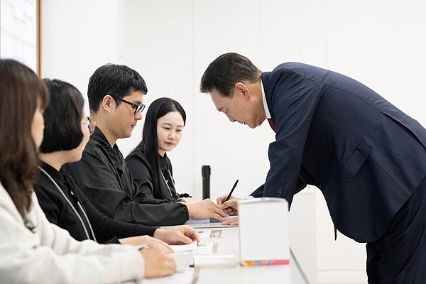  윤석열 대통령이 서울시교육감 보궐선거 투표 날인 16일 서울 용산구 용산공예관 투표소에서 본인 확인 뒤 서명하고 있다. 