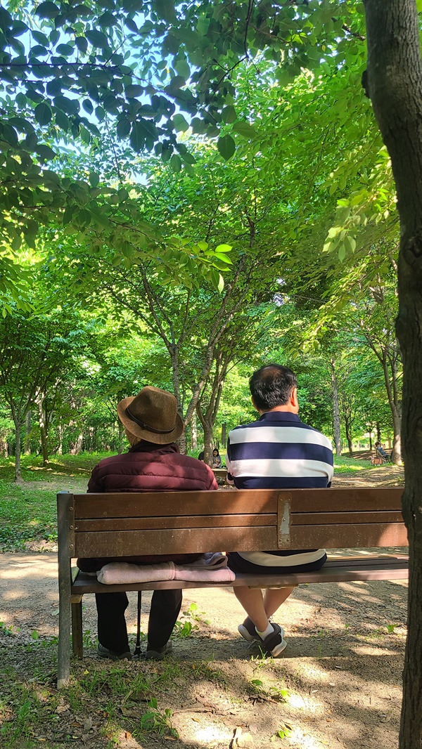  환갑이 된 아들과 구순의 아버지가 벤치에 앉아 있다.