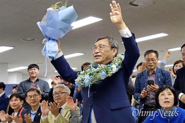  정근식 서울시교육감 후보가 16일 오후 11시 15분께 보궐선거 당선이 확실시되자 서울 마포구 선거사무소에서 꽃다발을 든 채 손을 들어보이고 있다.