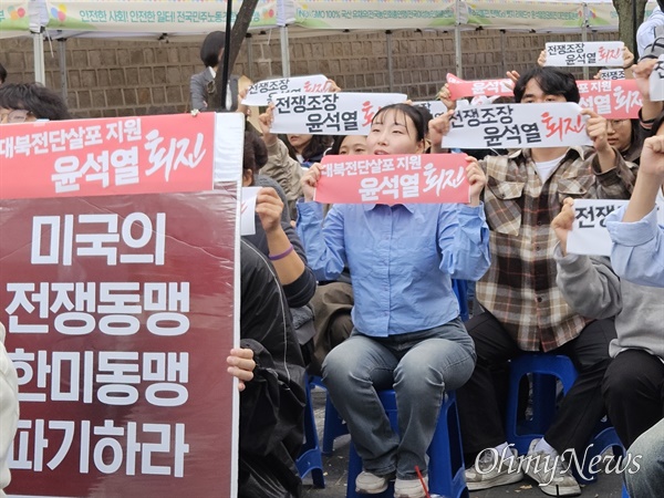  19일 오후 5시 서울 중구 덕수궁 돌담길에서 열린 '이러다가 전쟁난다! 전쟁조장 윤석열정권 퇴진! 반전평화대회'에 참석한 시민들이 구호를 외치며 손팻말을 들어 보이고 있다.