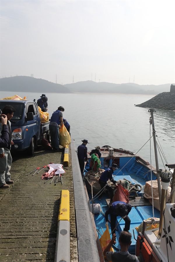  지난 17일 학암포 해안가에서 수거한 대형 해양 쓰레기를 태안발전본부 직원들이 선주협회 회원들과 함께 학암포항에 내리고 있다.