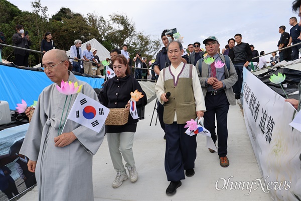  지난 26일 일본 야마구치현 우베시에 있는 조세이탄광 입구인 갱구 앞에서 열린 추모제에 참석한 보광원 주지 한우스님을 비롯한 한국 추모단 30여 명이 추모하기 위해 연꽃지화와 태극기를 들고 들어오고 있다.