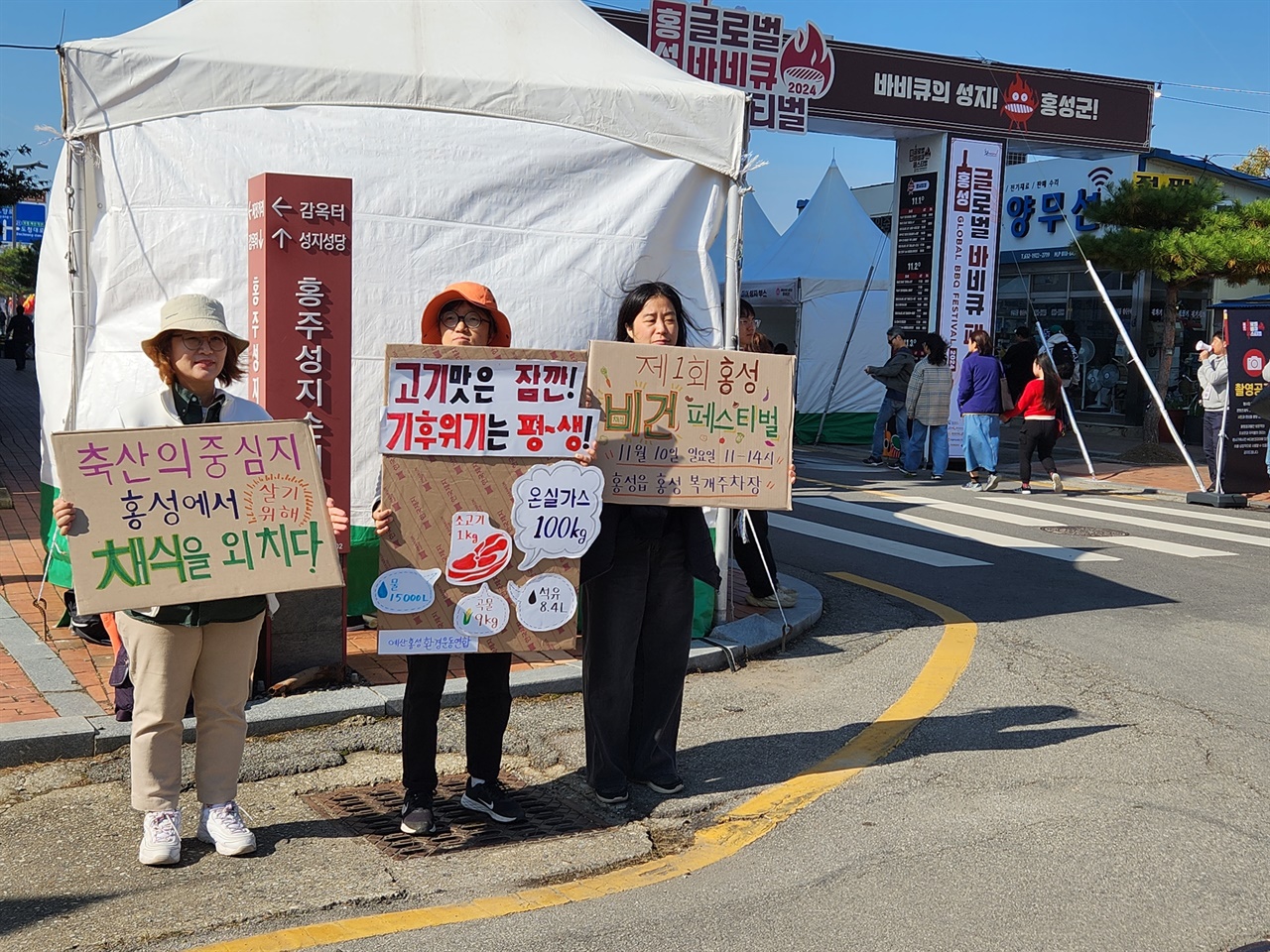  2일 충남 홍성군 바비큐 축제장 앞에서 지역 환경단체 활동가들이 피켓을 들고 있다.