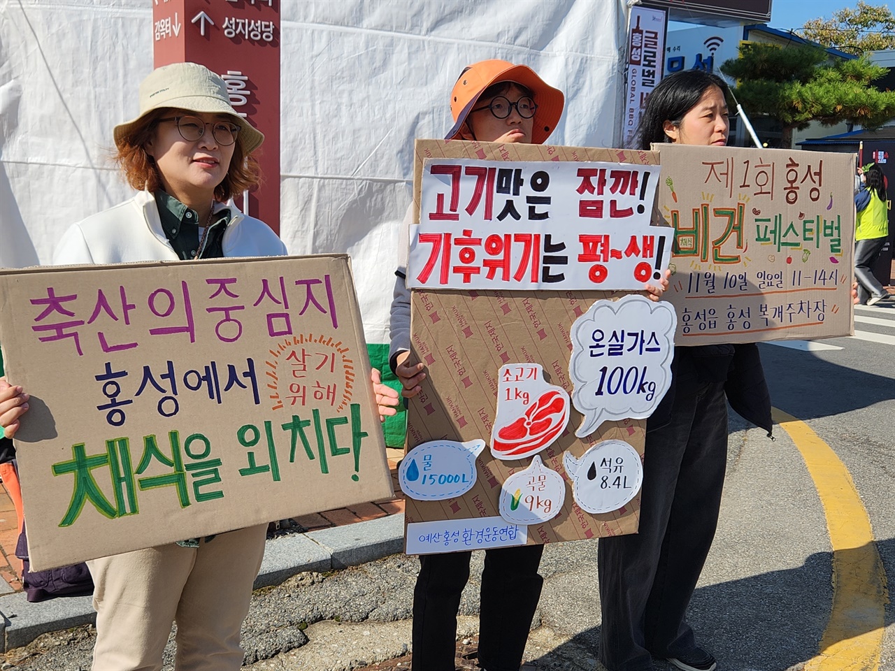  2일 충남 홍성군 바비큐 축제장 앞. 예산홍성환경운동연합 회원들이 피켓을 들고 있다.