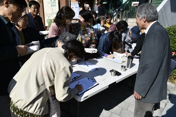  열심히 서명전에 임하고 있는 고산성당 신자들