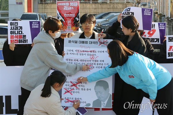 "이게 사과냐!" 윤석열OUT청년학생공동행동(2030정치공동체 청년하다, 대학생겨레하나, 진보대학생넷, 청년진보당, 평화나비네트워크, 한국청년연대, 행동하는경기대학생연대, 행동하는인하인권연대, 진보당 청소년특별위원회, 경북대학교 인권모임) 주최로 7일 오후 서울 용산구 대통령실 앞에서 열린 '이게 사과냐! 청년학생 긴급 기자회견'에서 참석자들이 "윤석열 대통령의 7일 대국민담화는 국정농단 의혹과 국민적 분노를 해소하기는 커녕 부정과 책임 회피로 일관했다"며 퇴진을 촉구하고 있다. 기자회견 참석자들이 윤석열 대통령의 '대국민담화문'을 첨삭하는 퍼포먼스를 하고 있다.