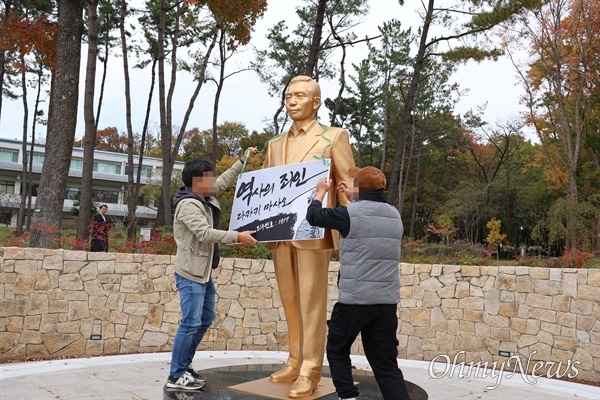  10일 오후 영남대 민주동문회 회원들이 천마아너스파크에 세워진 박정희 전 대통령 동상에 '역사의 죄인 다카키 마사오'라고 적힌 팻말을 걸고 있다. 