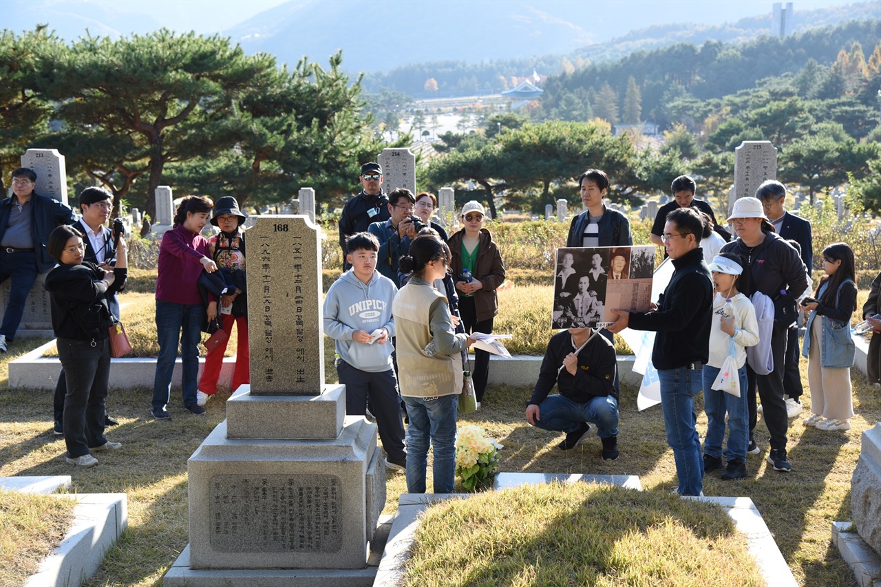  3코스 참가자들이 독립유공자2묘역에 안장된 문석봉의 묘 앞에서 황수정 해설사의 이야기를 듣고 있다.