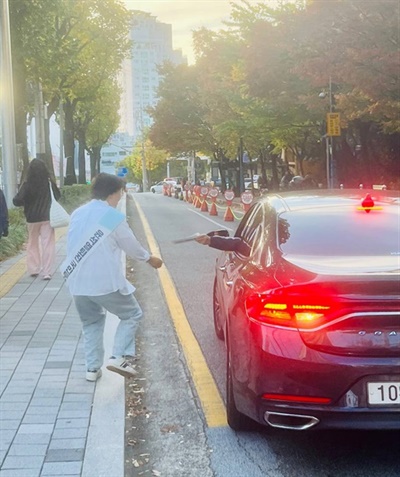 윤석열 퇴진 투표용지가 든 봉투를 차량을 타고 가다 투표소 자원봉사자에게 건네주는 부산시민 부산 이마트 연제점 앞에 자리한 투표소에 차를 타고 지나는 시민이 지인들에게 받은 투표용지가 든 봉투를 전달하고 있다.