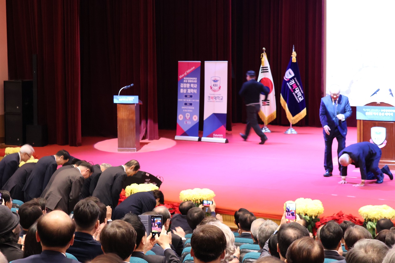  기념사에 나선 경복대학교 설립자 전재욱 박사가 임직원·학생 등을 향해 김 목사에게 인사하라고 하고 이들이 인사하자 김 목사는 엎드려 절하며 답례했다.