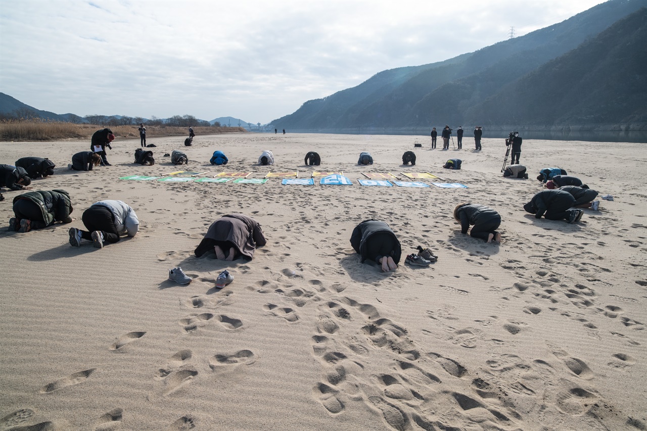  모래를 모시는 사람들. 2022년 1월 당시 합천창녕보 개방과 더불어 나타난 모래톱 위에서 생명평화절명상을 하고 있는 이들. 야생의 존재들과 더불어 살기 위해서 4대강 재자연화를 간절히 염원하면서 절을 올리고 있다.