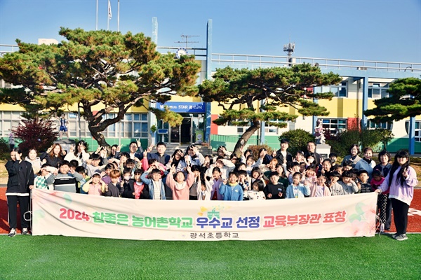  논산 광석초등학교 전교생과 교사들이 모여 '농어촌 참 좋은 학교' 선정을 축하하며 기념촬영을 했다