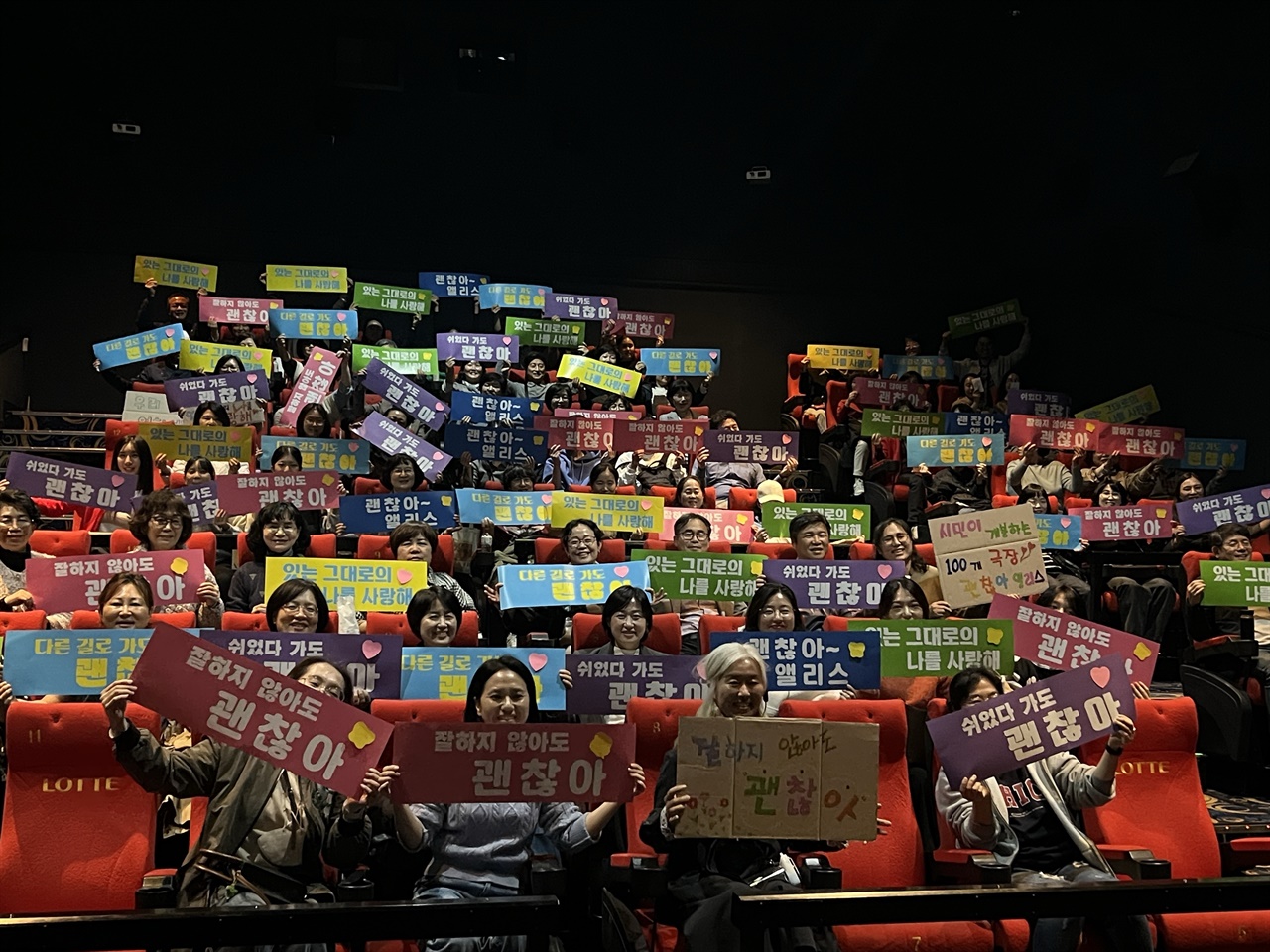  13일 저녁 롯데시네마 광주 수완아울렛관에서 '100개 극장 상영 관객추진단' 송경애(월계초 교장, 앞줄 오른쪽 2번째)씨와 관객들이 <괜찮아, 앨리스> 관람에 앞서 "괜찮아"라고 외치고 있다.