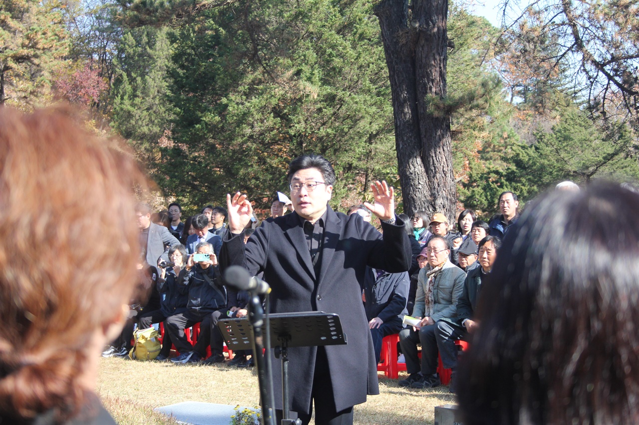 봄날 공연 종합예술단 <봄날>의 공연 중 지휘자가 노래하는 단원들 앞에서 손을 들어 지휘하는 모습이다. <봄날>은 이날 '그날이 오면', '철의 노동자' 두 곡을 공연했다.