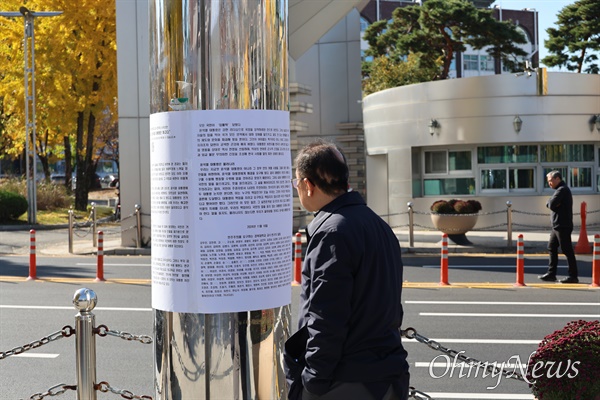  경북대 교수와 연구자들이 19일 경북대 북문 앞에서 시국선언문을 발표한 가운데 북문 기둥에 시국선언문을 붙여놓은 것을 지나가던 시민이 바라보고 있다.